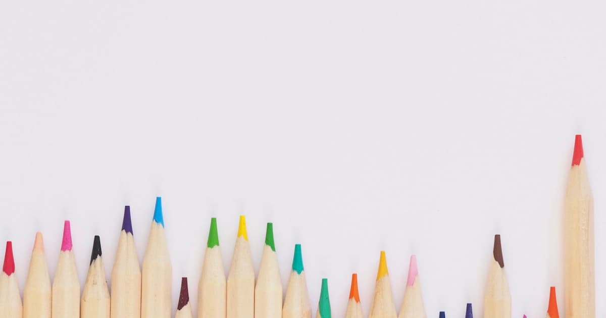 Colorful sticker designs spread across a workspace table with packaging materials